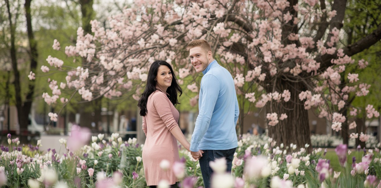 couple-souriant-parc-fleuri-printemps